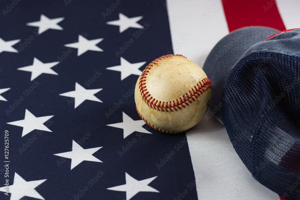 Baseball and hat on an American flag.
