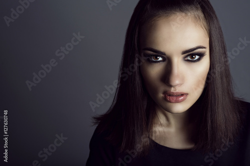 Φωτογραφία Portrait of gorgeous dark-haired young woman with provocative make up looking straight with aggression