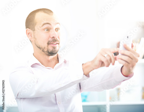 Positive young man with smartphone