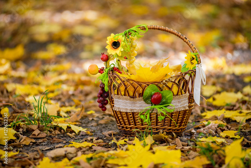 Autumn basket of with yellow leaf on a bed  autumnal foliage
