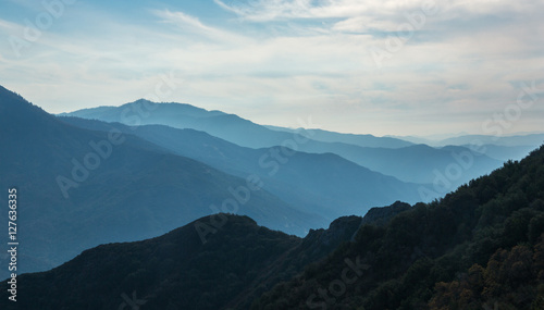 Fantastic evening light in misty valley hidden in the rocky moun