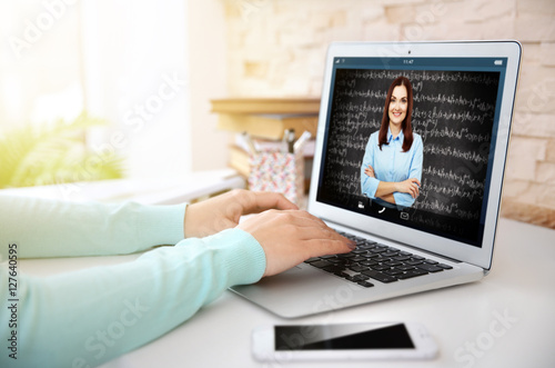 Woman video conferencing with tutor on laptop at home. Distance education concept.