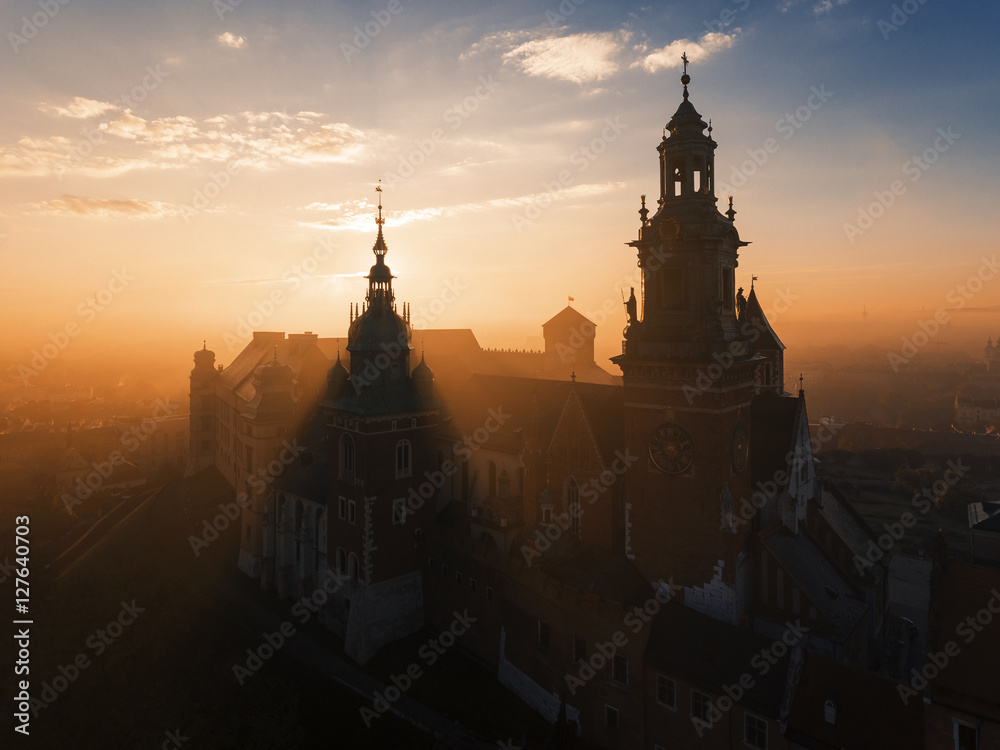 Naklejka premium Wawel castle at sunrise in the mystic fog, orange light 