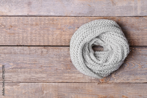 White knitted scarf on wooden background