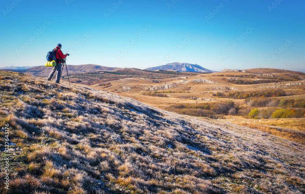 Obraz premium Photographer takes pictures on top of the mountain in autumn. 