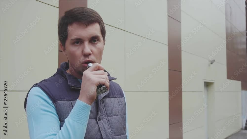 Young man is vaping outdoor slow motion HD Young man is vaping outdoor slow motion HD