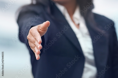 Business woman giving a handshake.