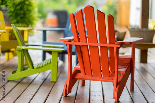 Colorful muskoka chairs for people to relax in during the tour. Beautiful lush green vineyard on a sunny summer day.