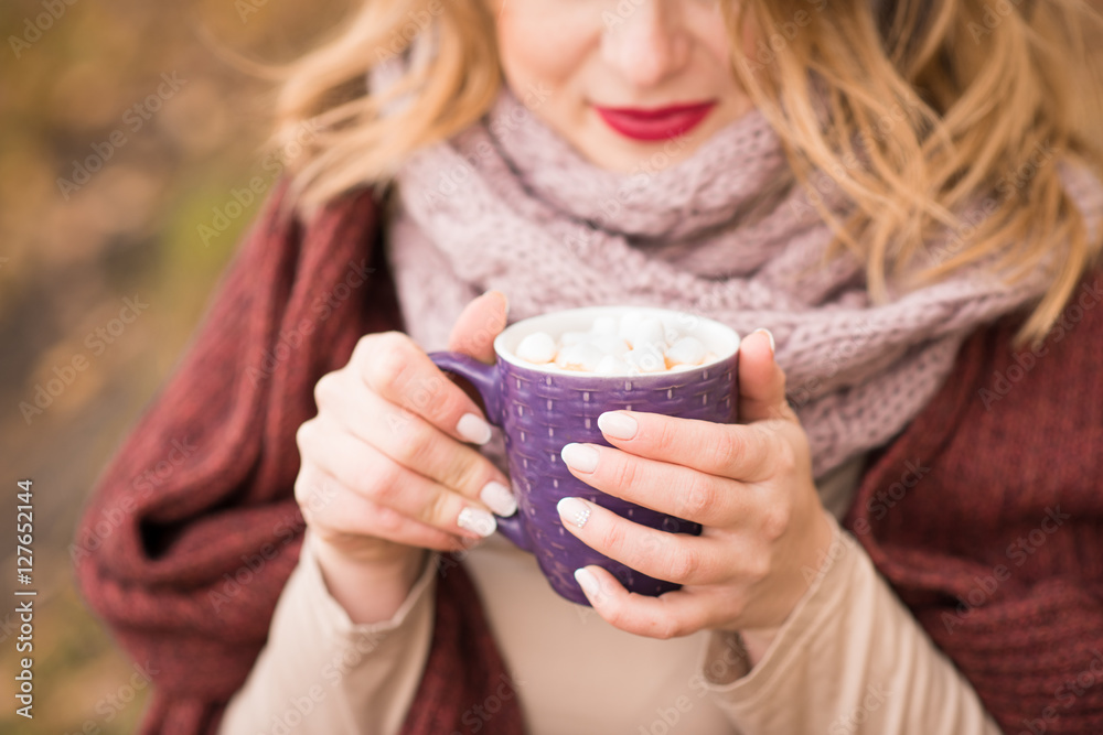 Pretty blonde enjoying hot chocolate marshmallows outdoors Pretty blonde enjoying hot chocolate marshmallows outdoors