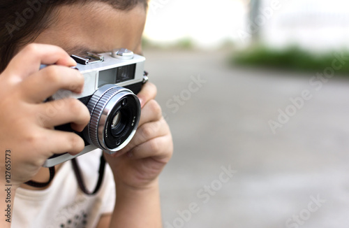 Little kid holding camera and taking photo.