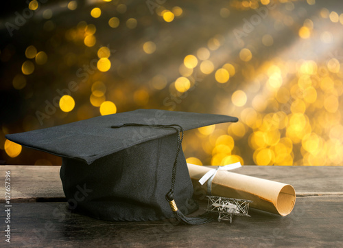 фотографія graduation cap, hat with degree paper on wood table, abstract li