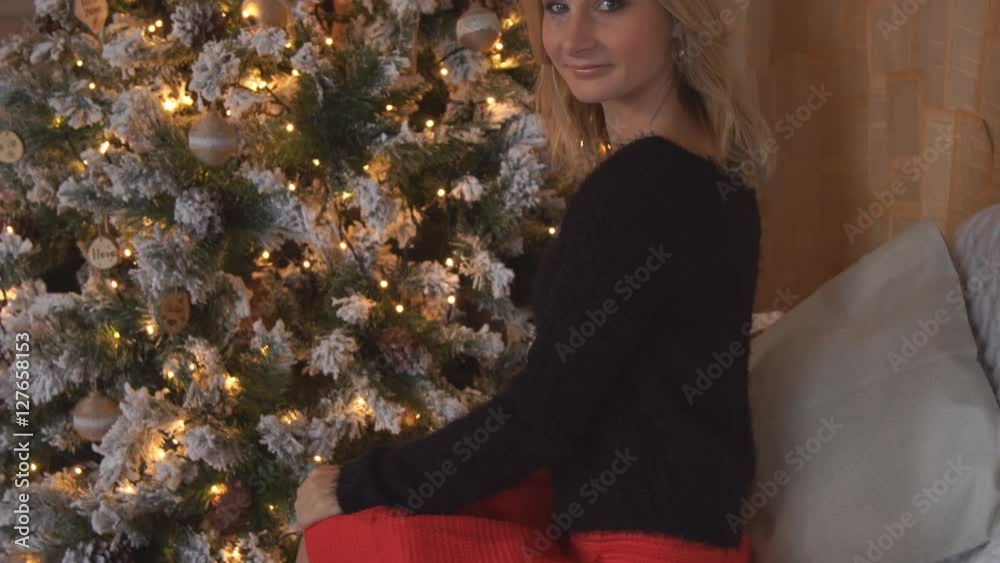 Young beautiful woman the christmas tree in nice decorating house Young beautiful woman the christmas tree in nice decorating house