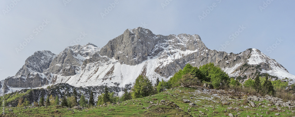 Obraz premium Landscape at Orobie Alps during spring season. Snow is melting. Valcanale area. Path from Alpe Corte lodge to Branchino natural lake. Arera Group of mountain