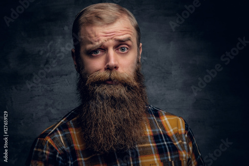 Obraz na plátně A bearded man dressed in a plaid shirt isolated on grey vignette