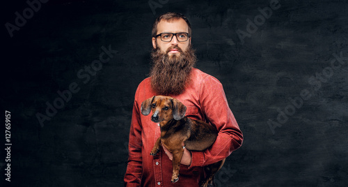 A bearded man dressed in a plaid shirt isolated on grey vignette