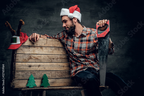 A man in Santa's hat presenting small fir trees and a hat with d