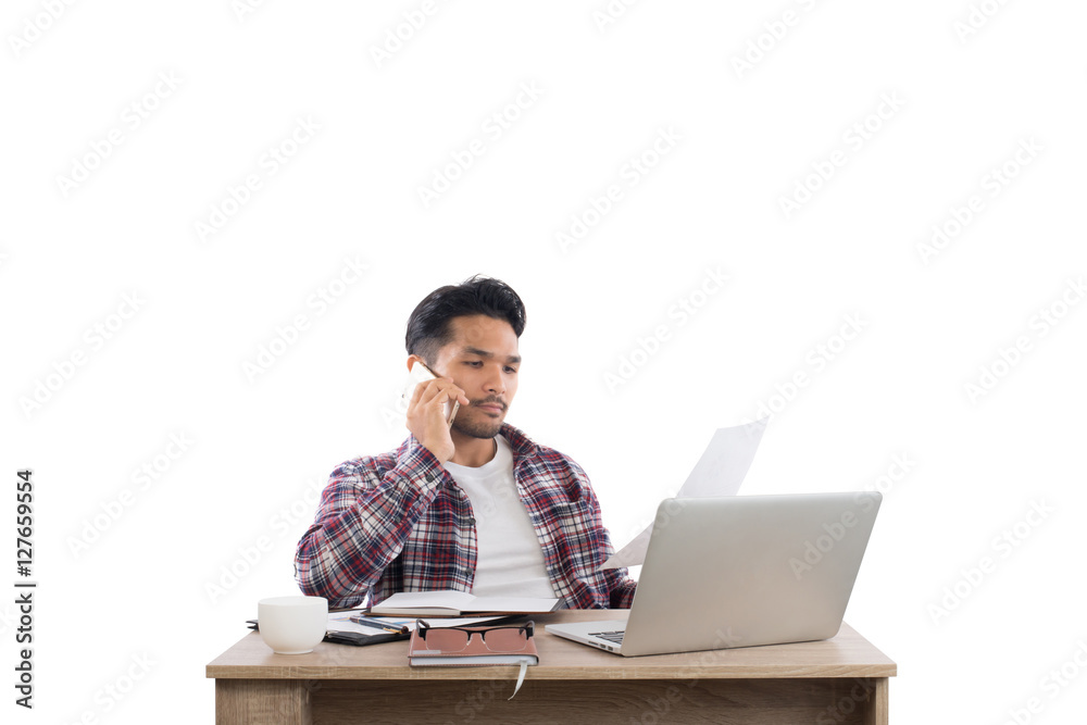 Businessman talking on the phone while work with laptop in the o Businessman talking on the phone while work with laptop in the o