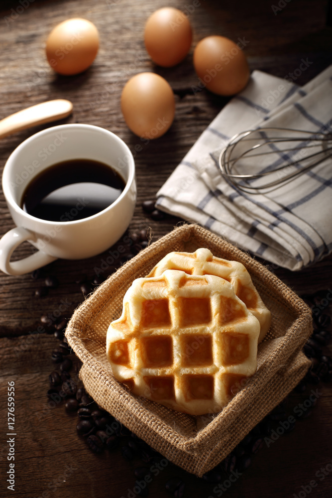 Fresh Waffles and hot coffee for breakfast set with eggs and wood background Fresh Waffles and hot coffee for breakfast set with eggs and wood background