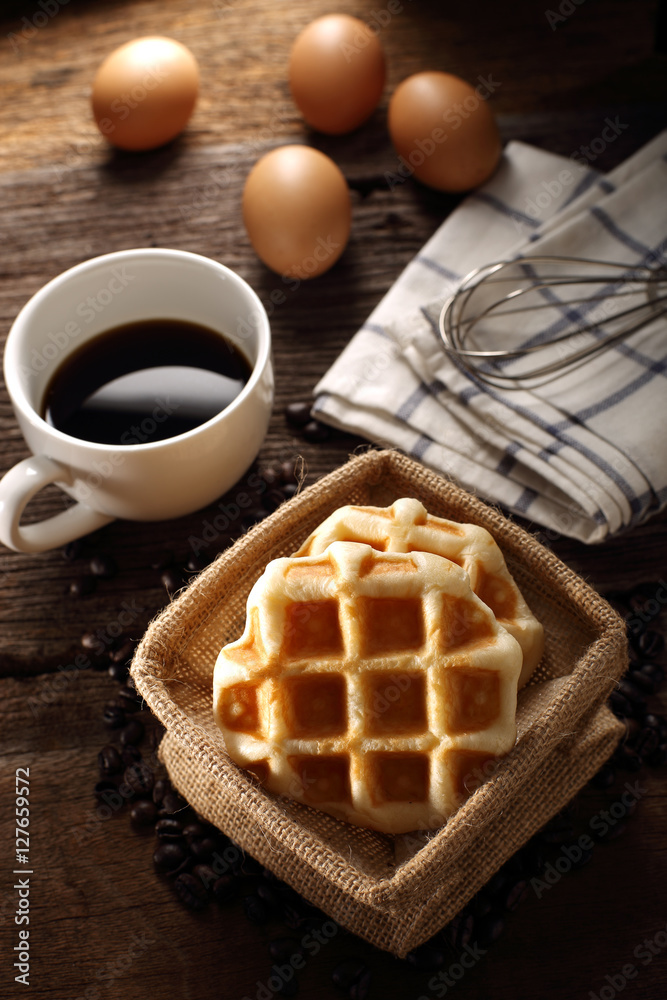 Fresh Waffles and hot coffee for breakfast set with eggs and wood background Fresh Waffles and hot coffee for breakfast set with eggs and wood background