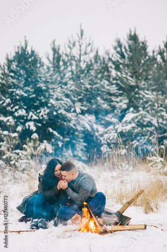 couple in love near the fire, winter, snow