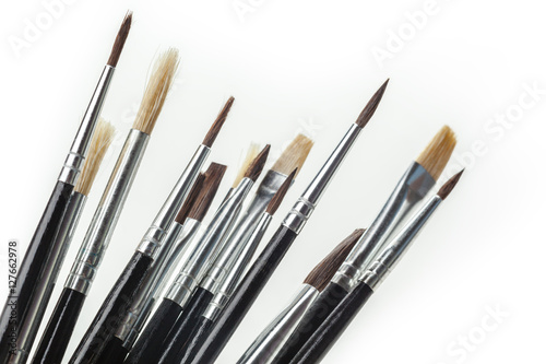 close up of paint brushes on white background