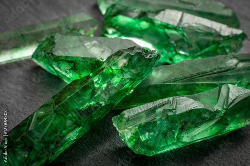 Closeup of a bunch of many green rough uncut emerald crystals