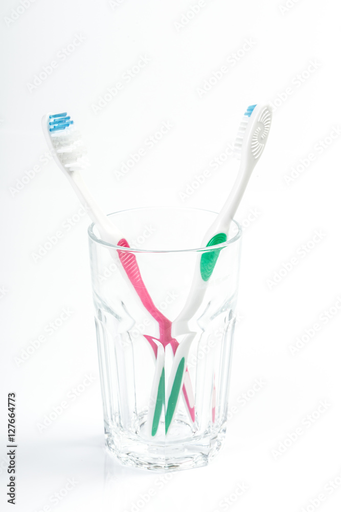 Toothbrushes in glass on table on light background Toothbrushes in glass on table on light background