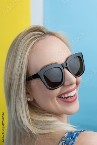 beautiful young blonde woman with elegant sunglasses posing in a