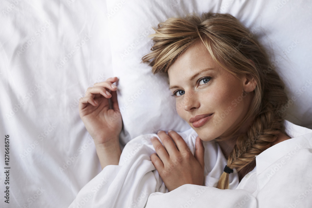 Beautiful blond woman lying on bed, portrait Beautiful blond woman lying on bed, portrait