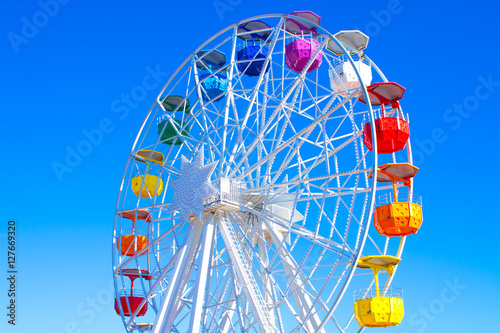 Multicolour ferris wheel on blue sky background	 photo