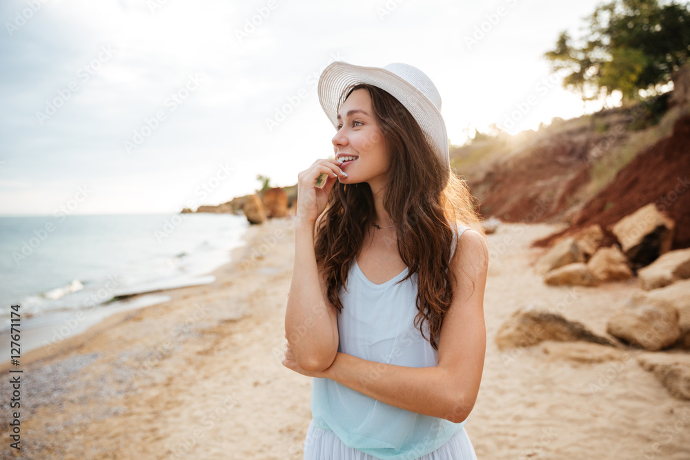 Cheerful young woman walking on the beach