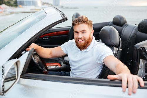 Fotografie Smiling bearded man getting out of his car