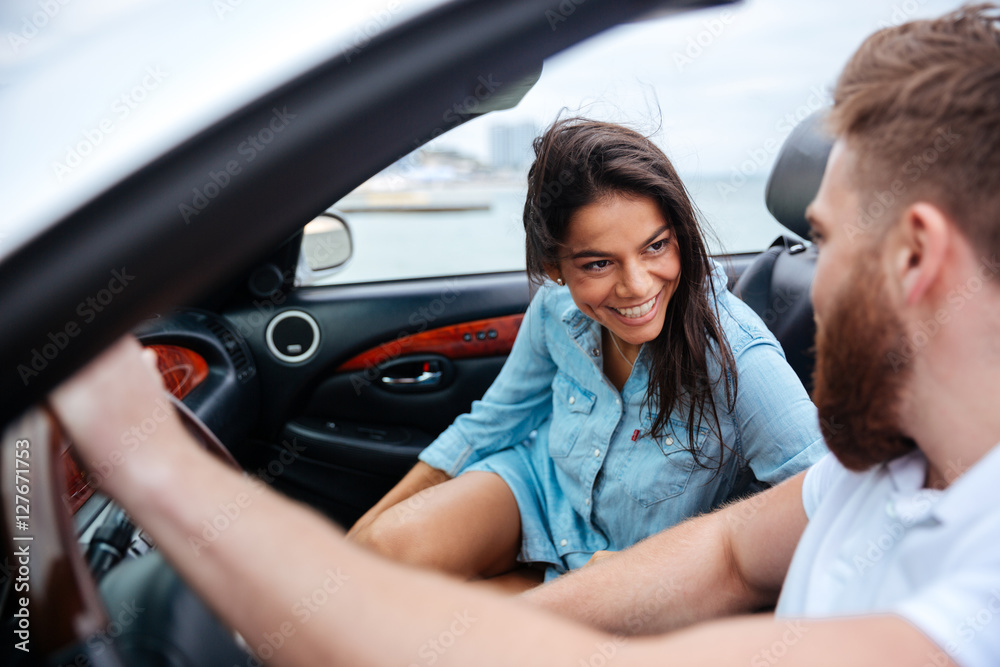 Happy man and woman driving in cabriolet car Happy man and woman driving in cabriolet car