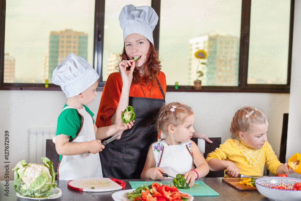 Three cute kids with mom making fruit salad Three cute kids with mom making fruit salad