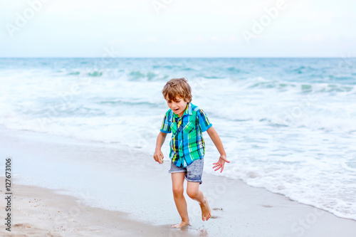 little kid boy running on the beach of ocean © Irina Schmidt
