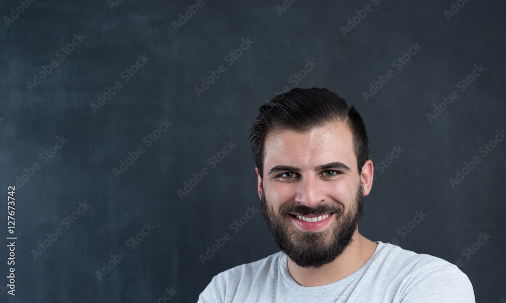 A confident handsome young man standing in front of a dark backg A confident handsome young man standing in front of a dark backg