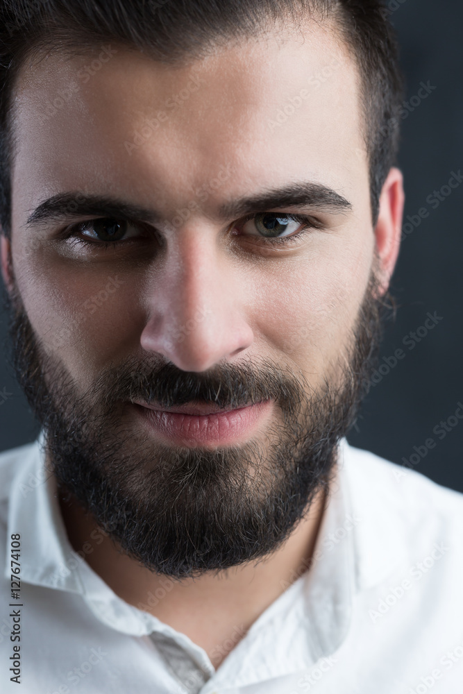 Fototapeta premium Portrait of a young bearded man against black chalkboard