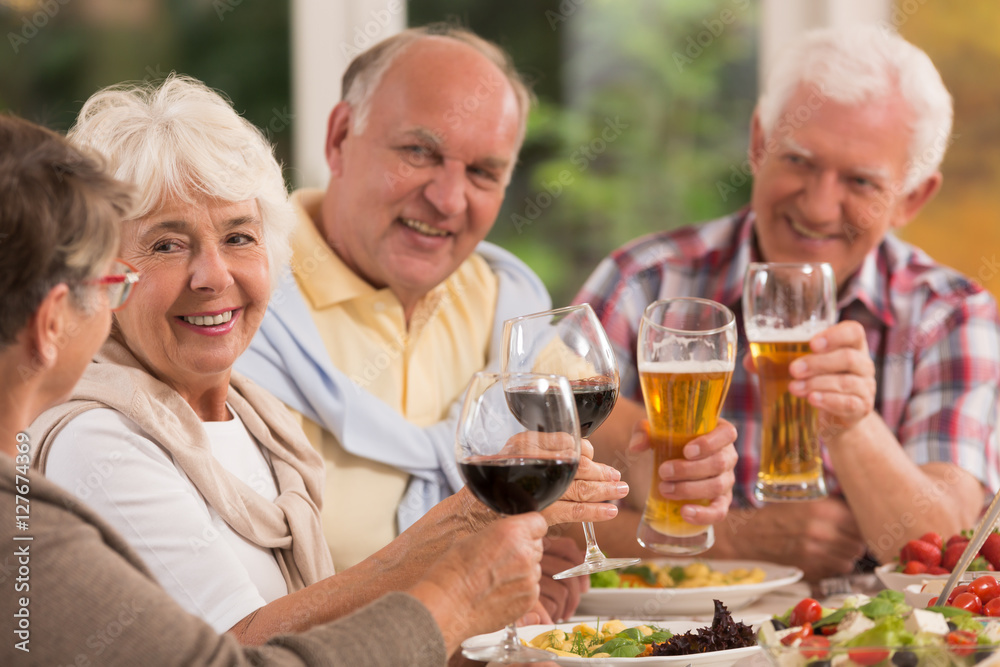 Happy elderly friends drinking beer