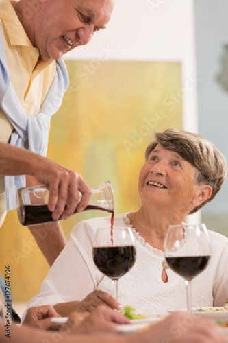 Pouring her glass of wine during a meal