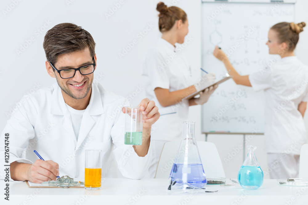 Young scientist writing down his findings Young scientist writing down his findings