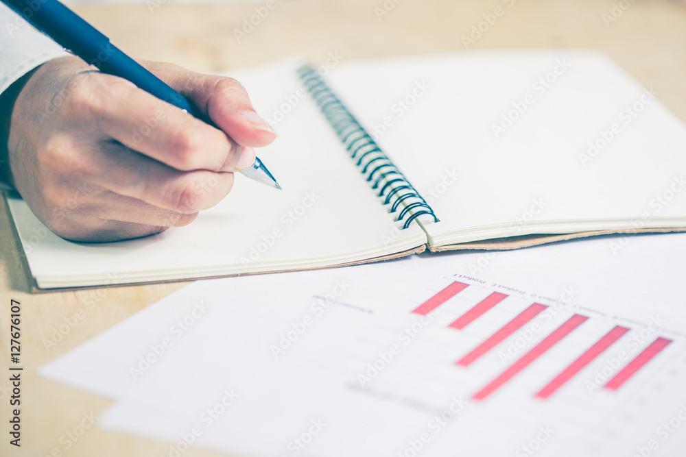 Business women hands working writing notebook on wooden desk, li Business women hands working writing notebook on wooden desk, li