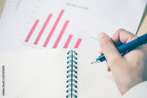 Business women hands working writing notebook on wooden desk, li photo