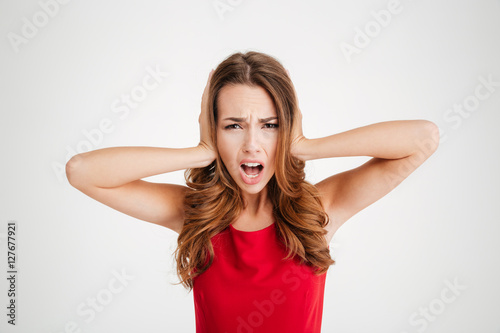 Stressed upset young woman covered ears by hands