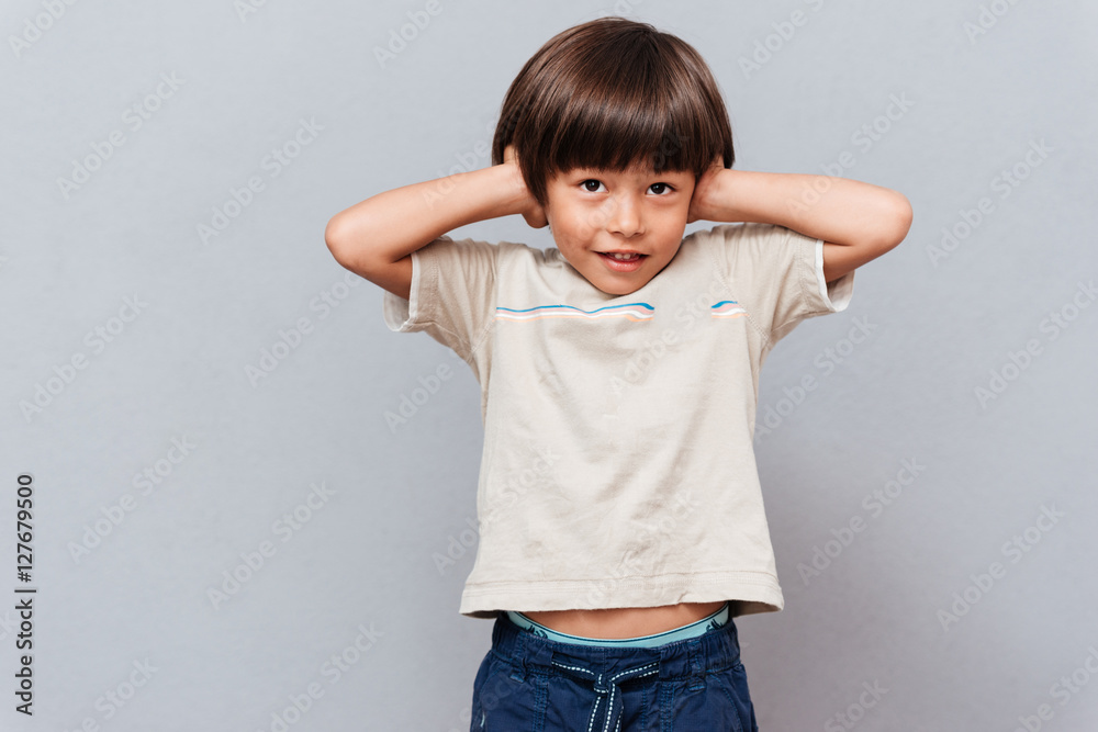 Cute little boy covered ears by hands Cute little boy covered ears by hands