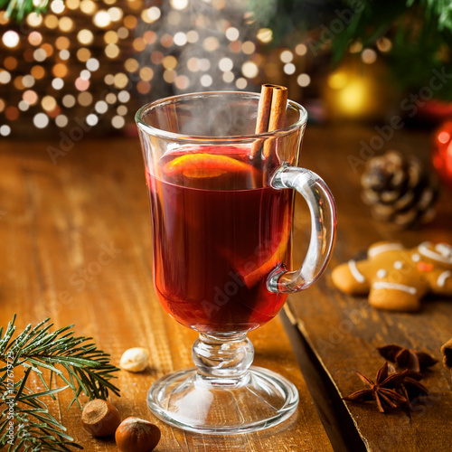 Mulled wine for Christmas Eve celebration party by Christmas tree. Hot traditional winter drink for New Year eve.