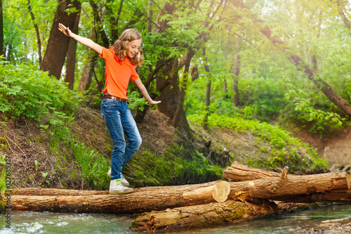 Εκτύπωση καμβά Cute girl balancing while crossing a log bridge