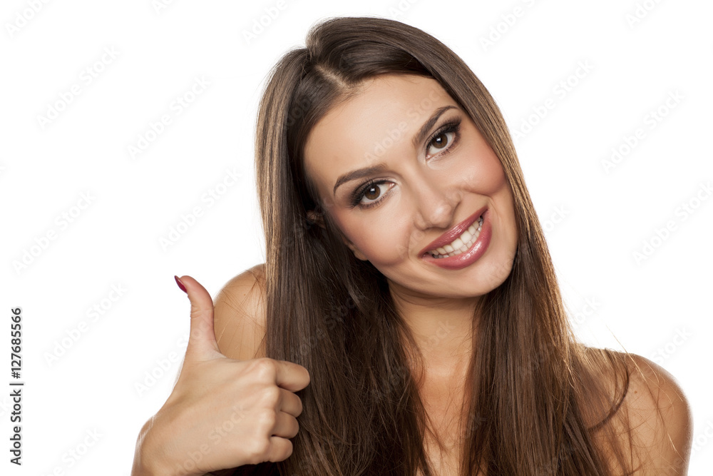 portrait of a beautiful young woman showing thumbs up on a white background portrait of a beautiful young woman showing thumbs up on a white background