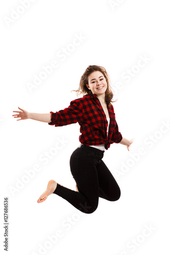 Young woman jumping on white background 