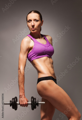 Confident healthy strong woman with dumbell