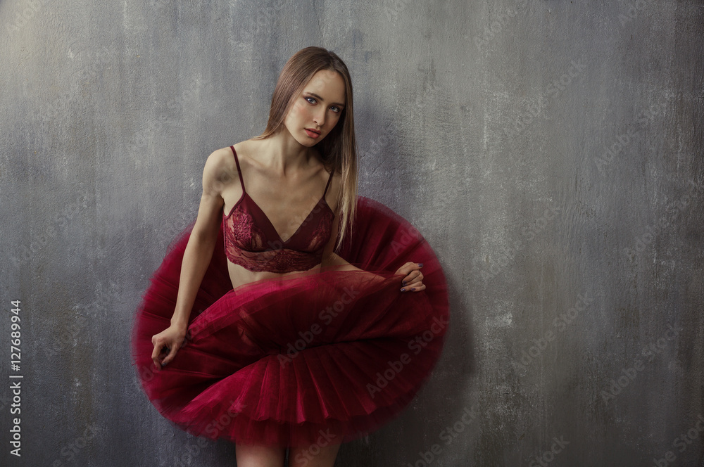 Portrait of slim young girl in a red tutu which is against the b Portrait of slim young girl in a red tutu which is against the b